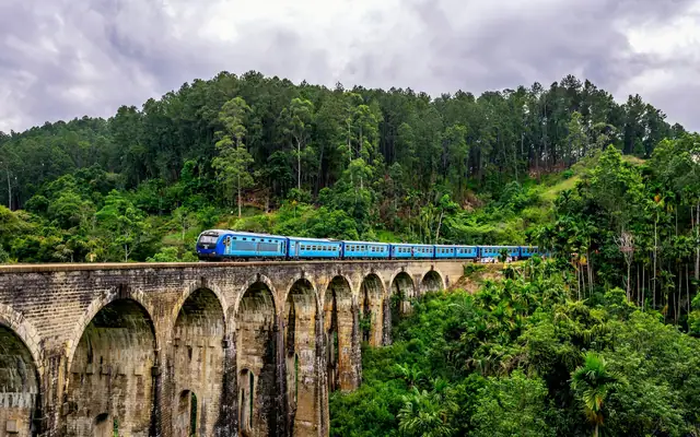 Blue train crossing the Nine Arches Bridge in Ella