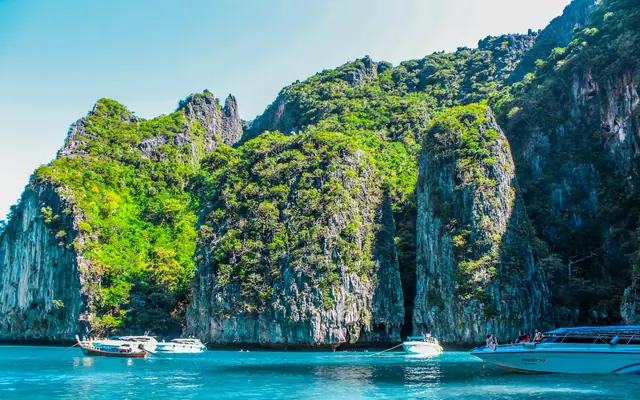 Longtail boat beneath limestone cliffs in Krabi