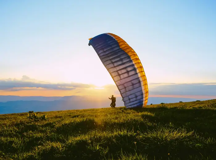 Paraglider silhouetted against the sunset