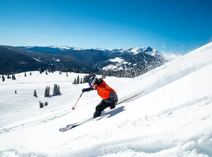Skier carving down a snowy slope