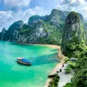 Boats on turquoise water among limestone karsts in Ha Long Bay
