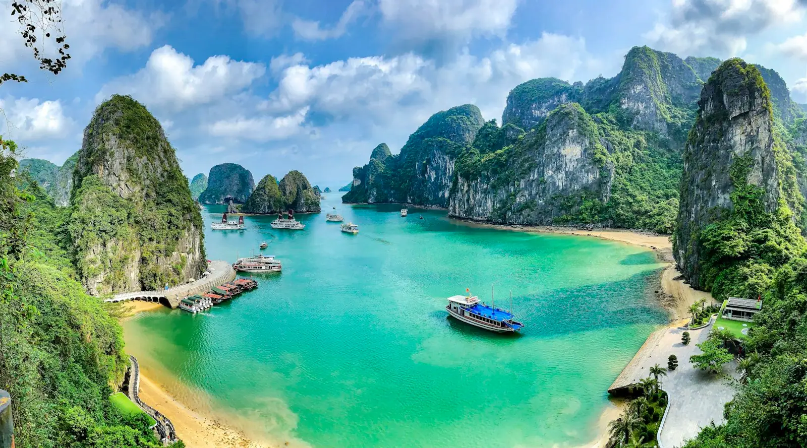 Boats on turquoise water among limestone karsts in Ha Long Bay